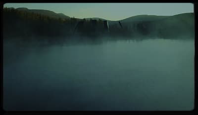 a body of water surrounded by mountains and trees