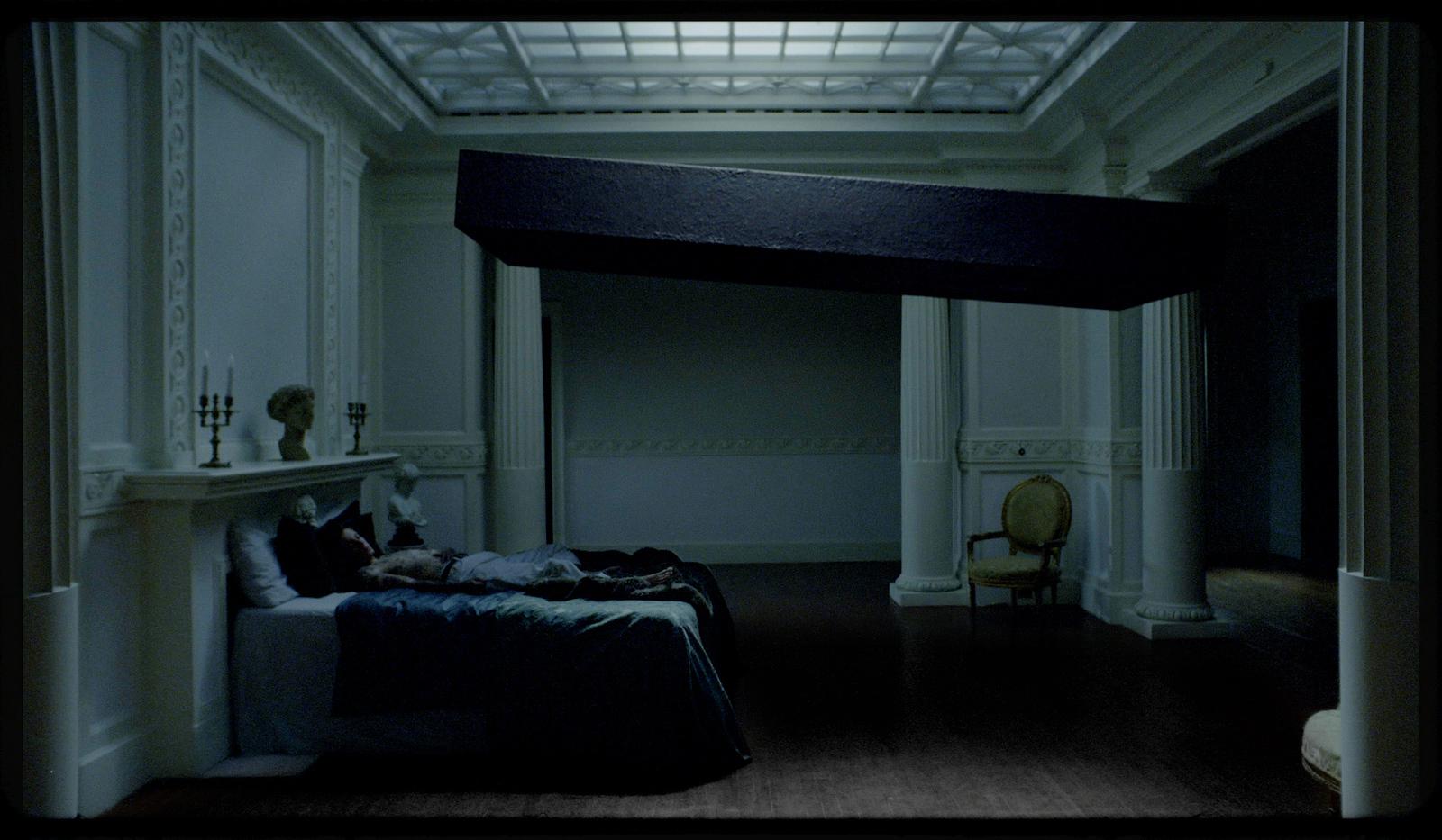 a person laying on a bed in a dimly lit room