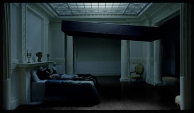 a person laying on a bed in a dimly lit room