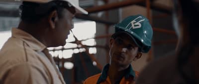 two men wearing hard hats in a factory