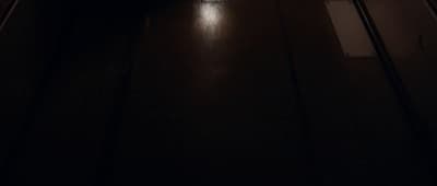 a dark hallway with a clock on the wall