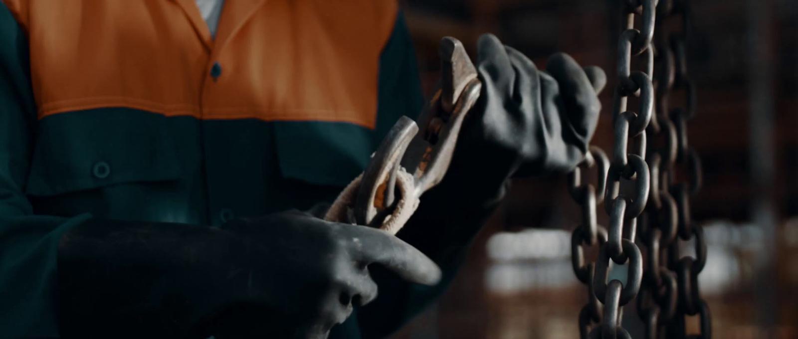 a person in a green and orange shirt holding a piece of wood