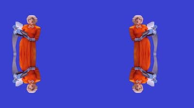 a woman in an orange dress is standing in front of a blue background