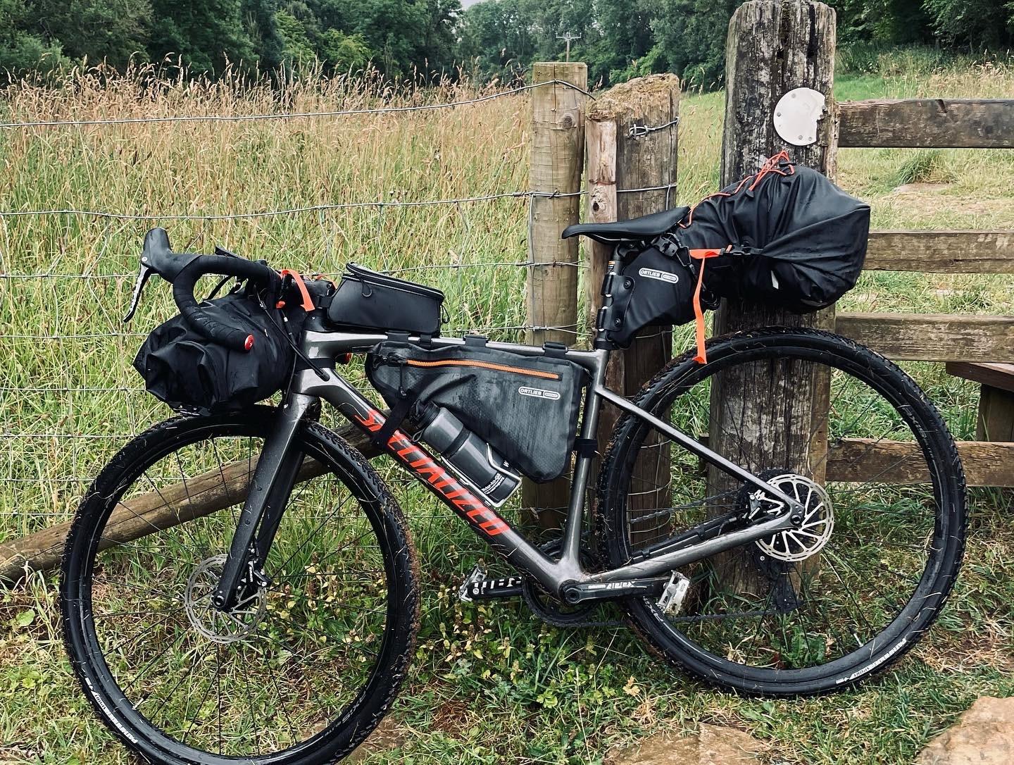 a bicycle parked next to a wooden fence