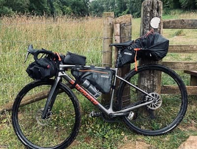 a bicycle parked next to a wooden fence