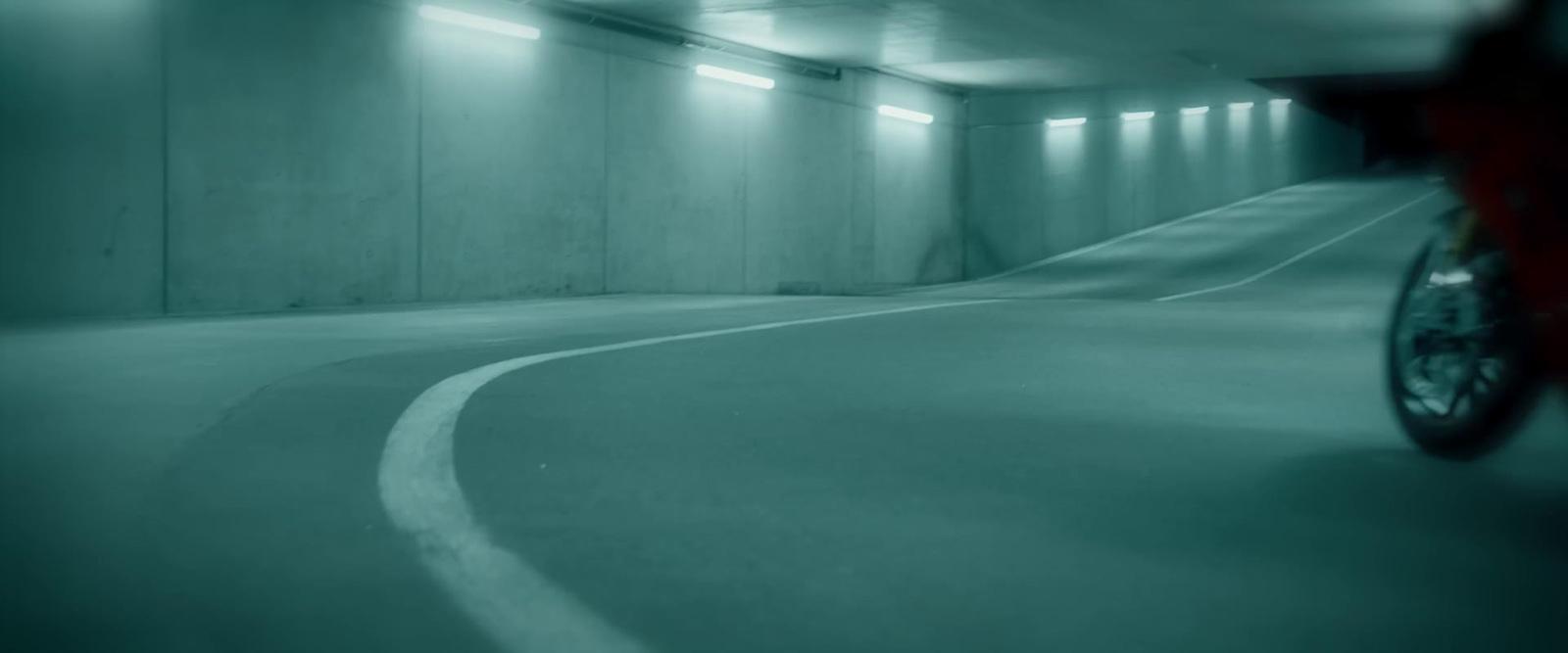 a person riding a bike in a parking garage
