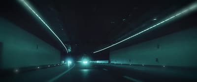 a car driving through a tunnel at night