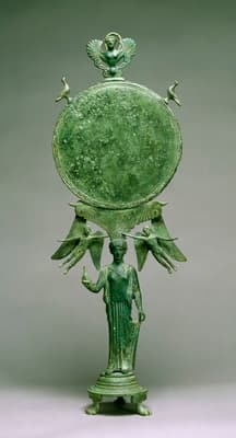 a green vase with a statue of a man holding a bird