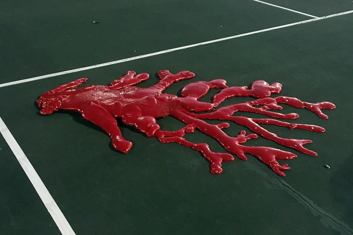 a tennis court with a red substance on it