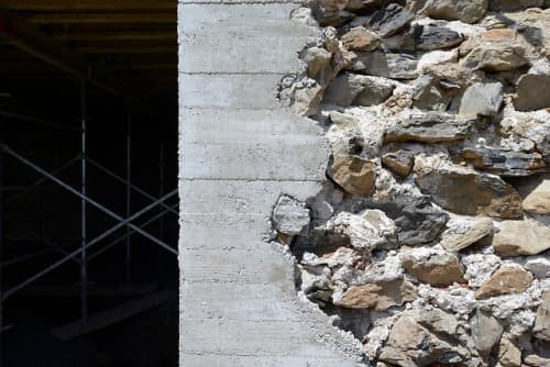 a close up of a stone wall with scaffolding in the background