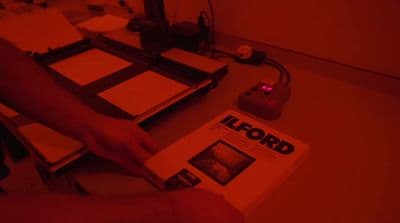 a person holding a book in front of a red light