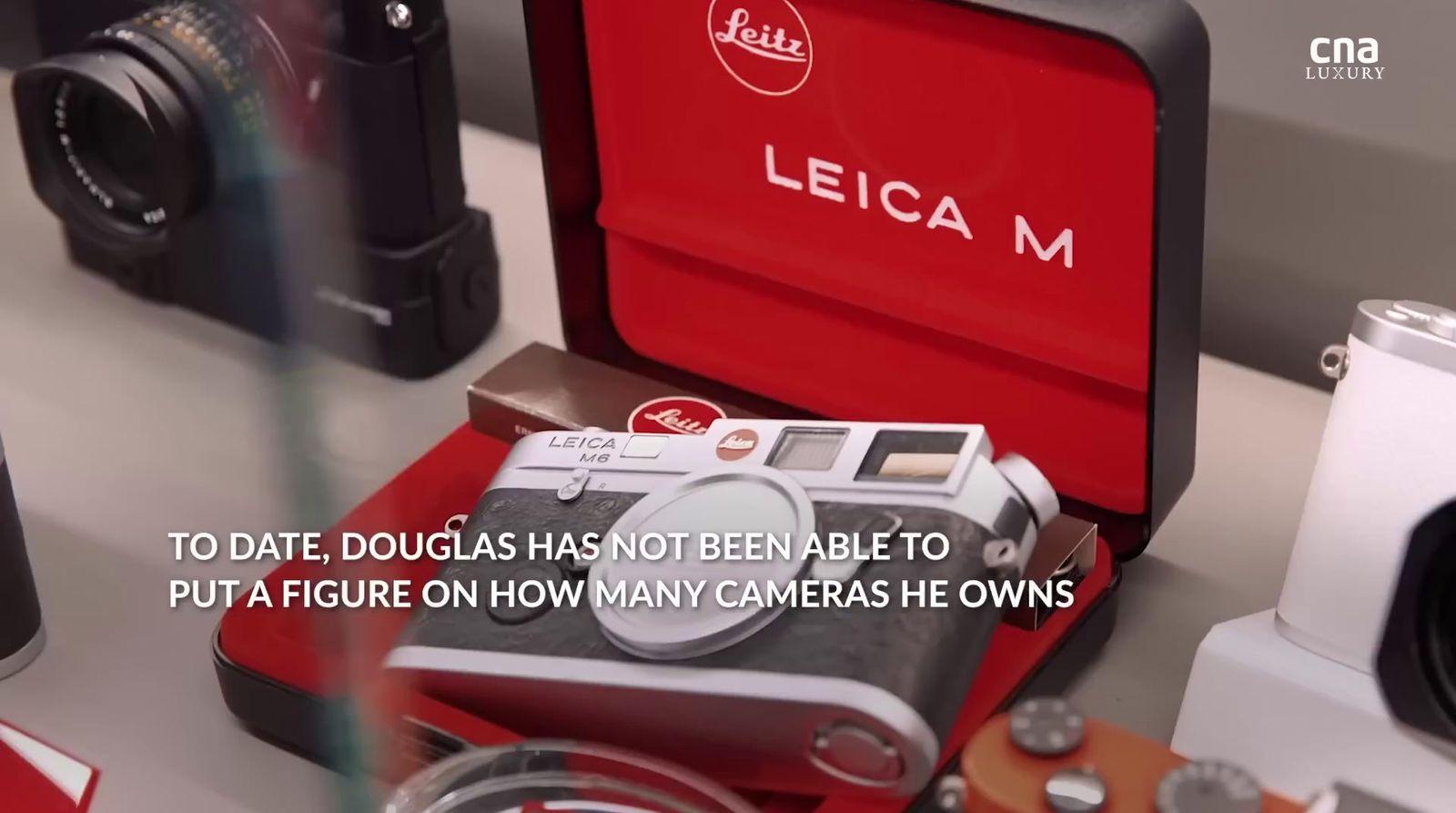 a red camera sitting on top of a table next to other cameras