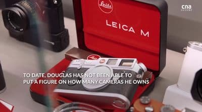 a red camera sitting on top of a table next to other cameras