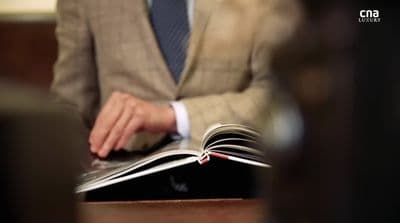 a man in a suit is reading a book