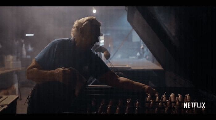 a man sitting at a piano in front of a microphone