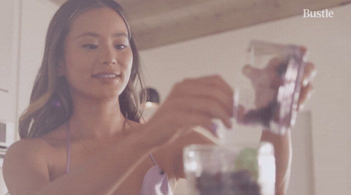 a woman is holding a blender in her hand