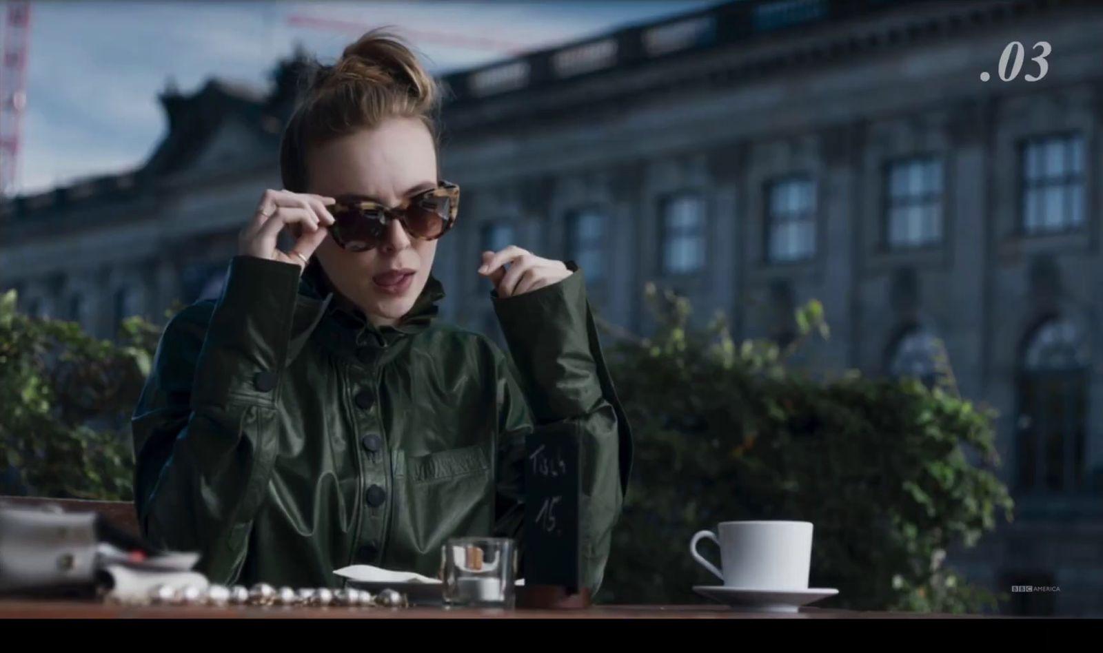 a woman sitting at a table with a cup of coffee