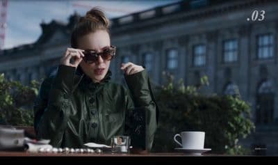 a woman sitting at a table with a cup of coffee