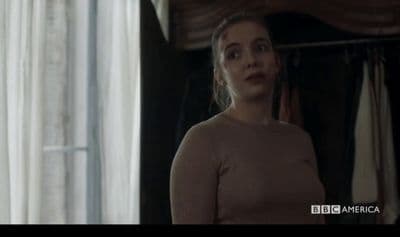 a woman standing in front of a window