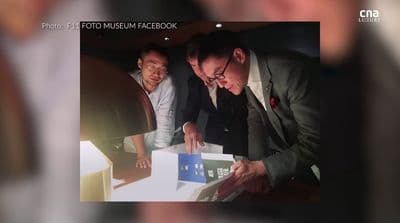 two men looking at a box with a picture on it