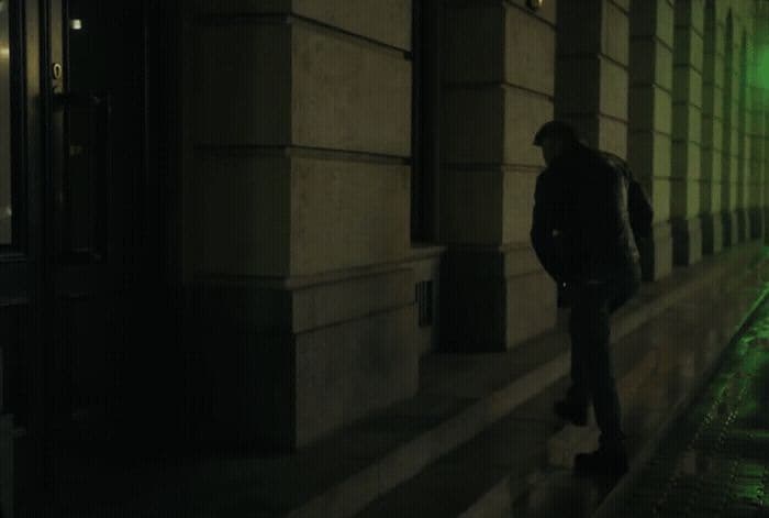 a man standing on a sidewalk next to a building