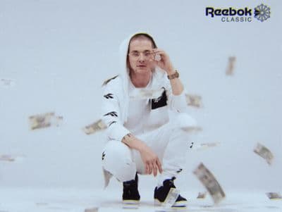 a man in a white outfit is sitting on a pile of money
