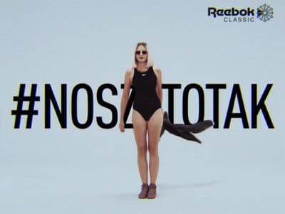 a woman in a bathing suit standing in front of a sign