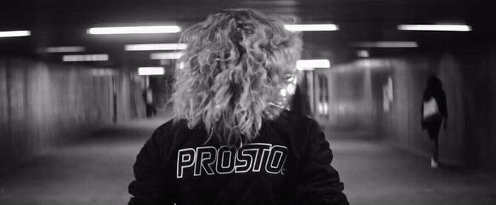 a person with long hair standing in a hallway