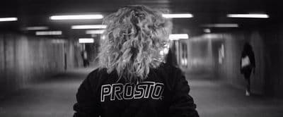 a person with long hair standing in a hallway