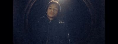 a young boy standing in a dark tunnel