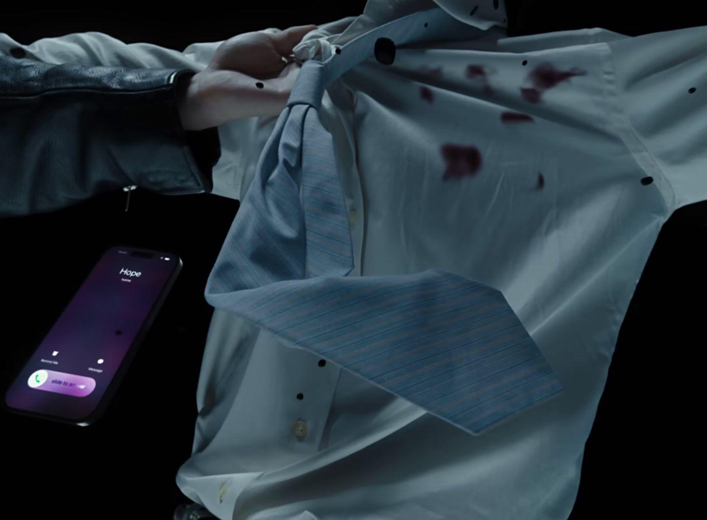 a person holding a cell phone with a tie on it