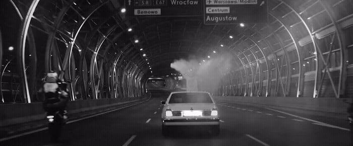 a black and white photo of a car in a tunnel