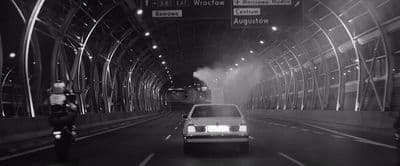a black and white photo of a car in a tunnel