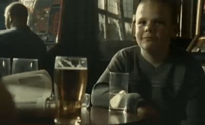 a man sitting at a table with a glass of beer