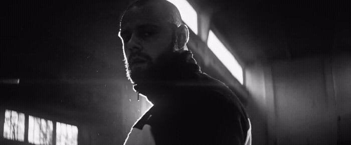 a man standing in a dark room next to a window
