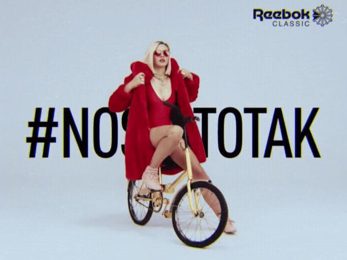 a woman in a red coat riding a bike