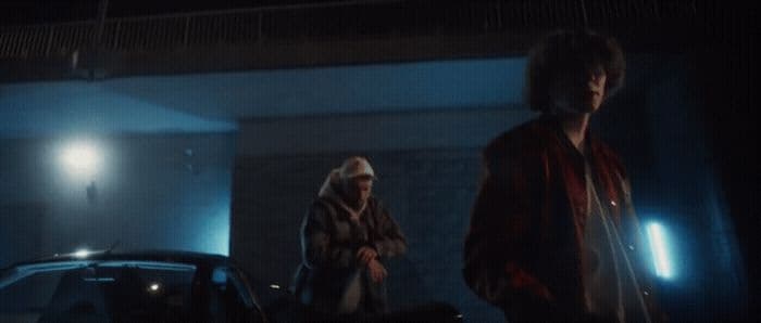 a couple of people standing next to a car