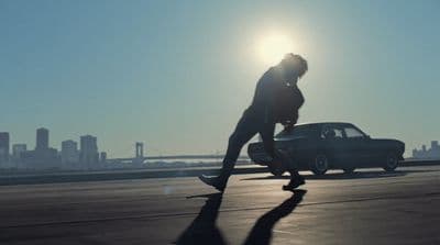 a person riding a skateboard next to a car