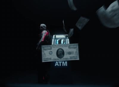 a man standing in front of a stack of money