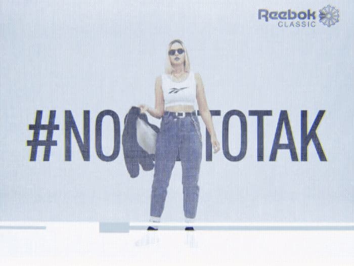 a woman standing in front of a no to talk sign