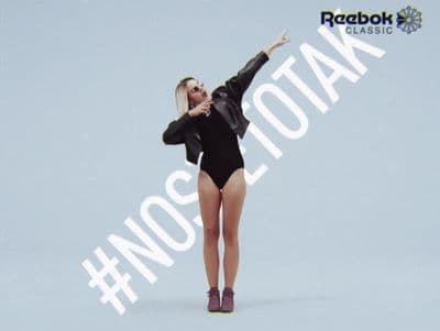 a woman in a black bodysuit is posing for a picture