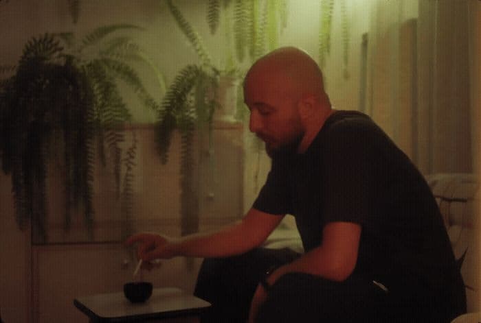 a bald man sitting on a chair in a living room