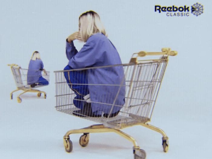 a woman sitting in a shopping cart in front of a mirror