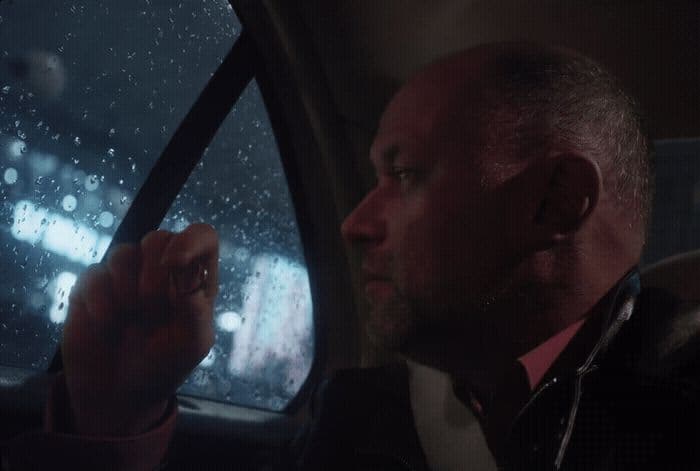 a man driving a car in the rain