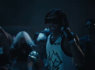 a man in a tank top talking on a cell phone