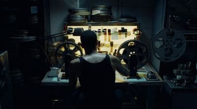 a woman standing in front of a machine in a dark room