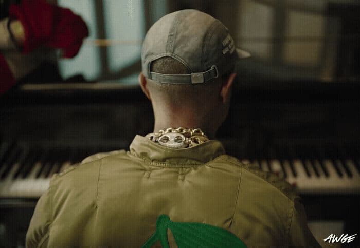 a man in a baseball cap is looking at a piano
