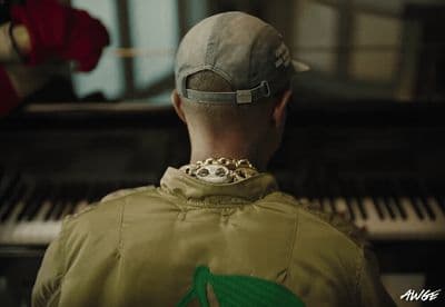 a man in a baseball cap is looking at a piano