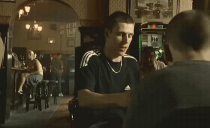 a man sitting at a bar talking to another man