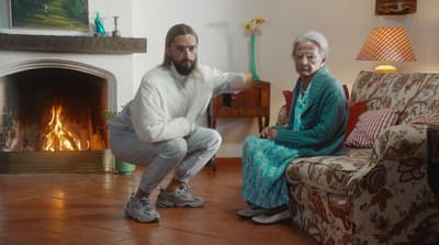 a man and a woman sitting in front of a fire place
